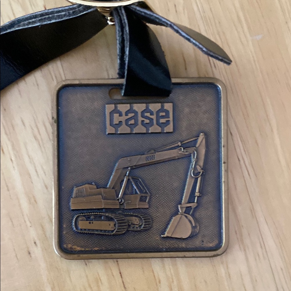 Case Bronze Excavator Keychain with leather strap.